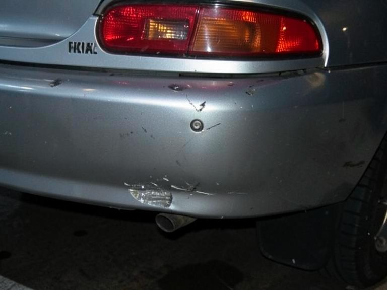 Rear bumper of a sedan with impact damage before repair
